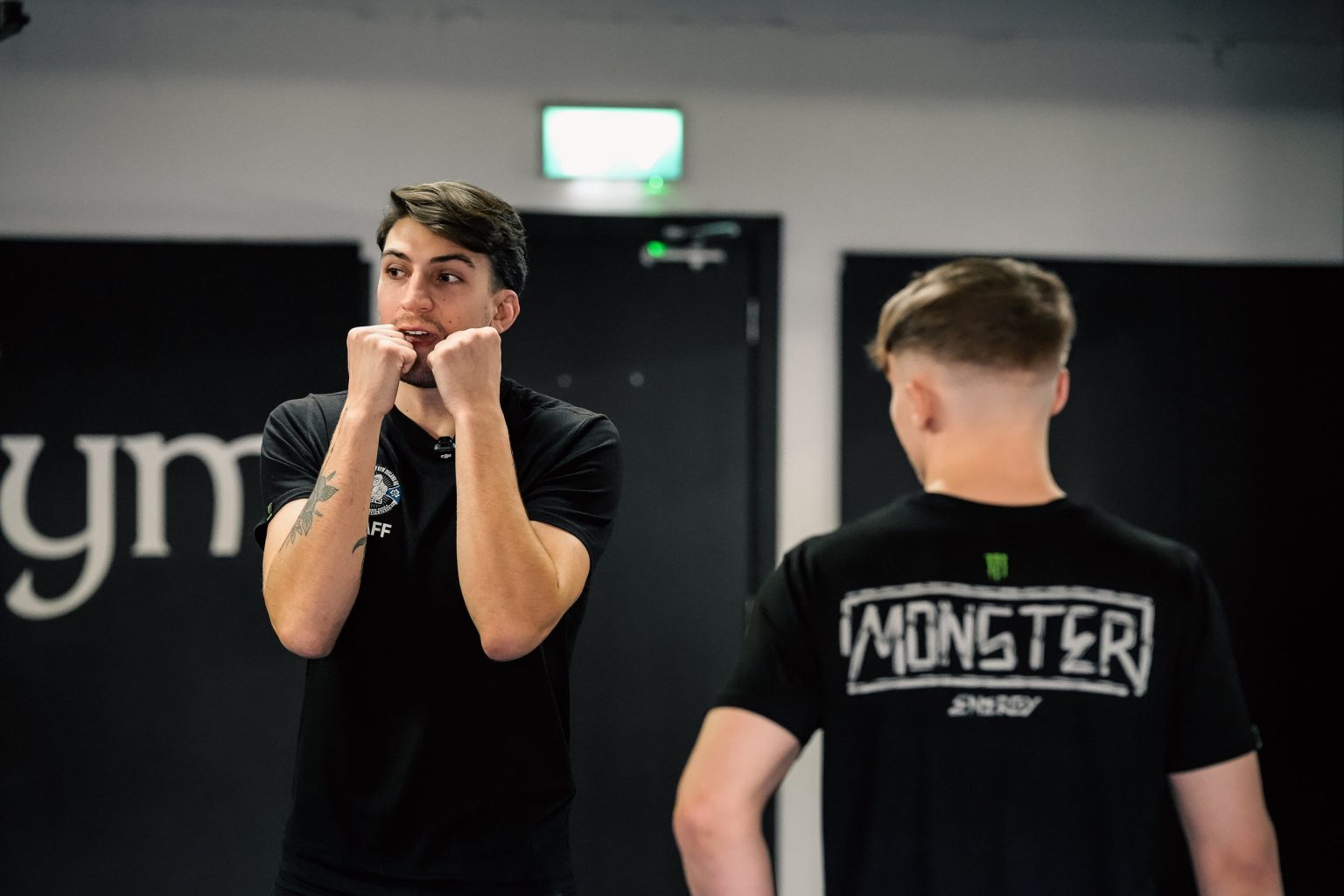 SBG coach demonstrating a guard stance during an MMA class