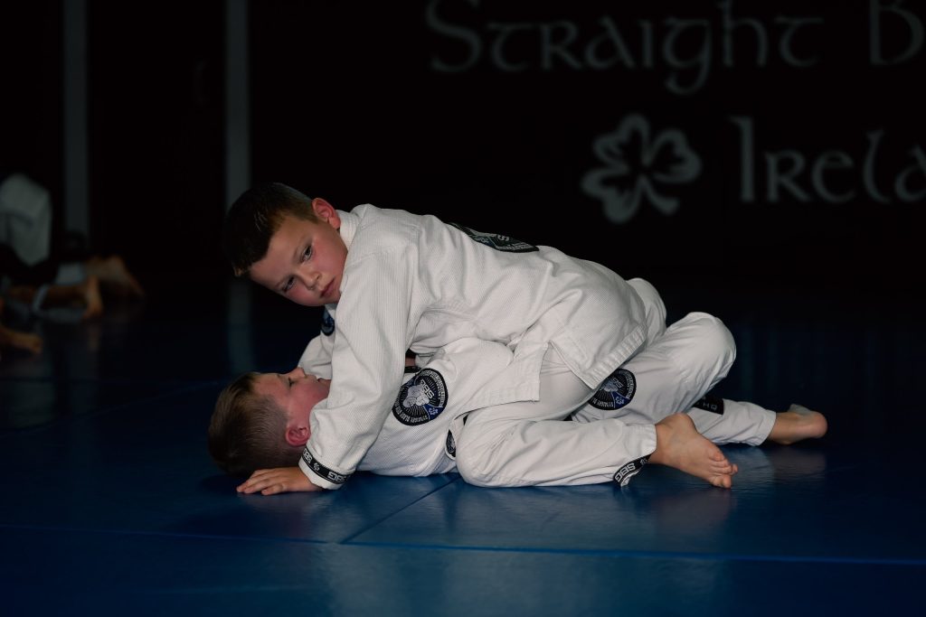 Two boys in white SBG gis grappling on the mats at SBG Ireland HQ
